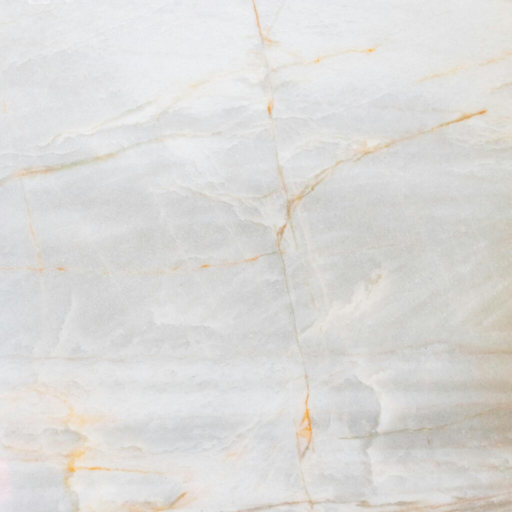 Close-up of a smooth marble surface featuring intricate natural veining and soft tones.
